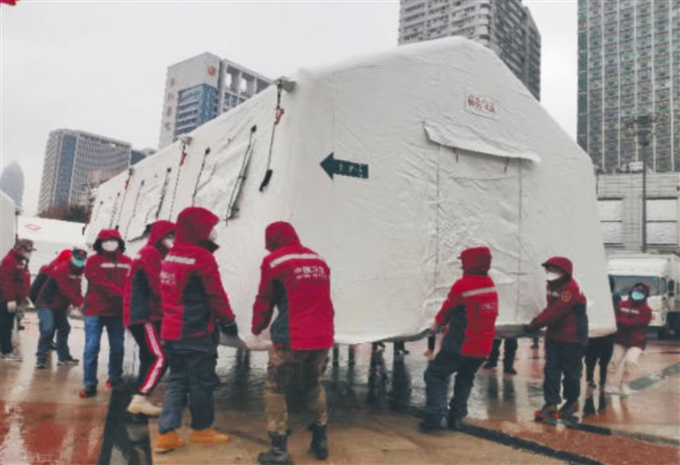 国家紧急医学救援队（海南）队员在武汉国际会展中心方舱医院外的广场上撑起帐篷