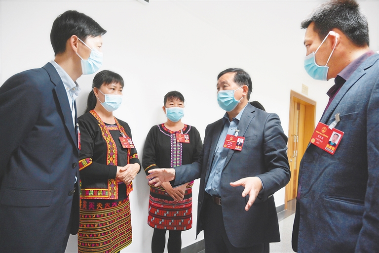 李健保代表和几位基层代表在一起讨论山区教育提质的问题