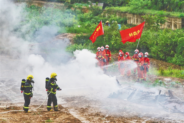 在演练现场，扑火队员在对“森林火灾”进行扑救